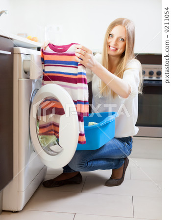 woman with clothes near washing machine woman with clothes near washing machine 9211054