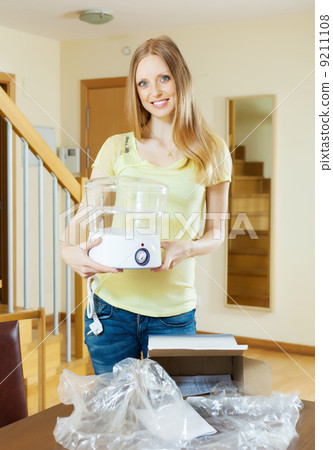 Young woman with new electric steamer Young woman with new electric steamer 9211108