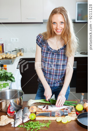 blonde woman slicing raw fish blonde woman slicing raw fish 9211128