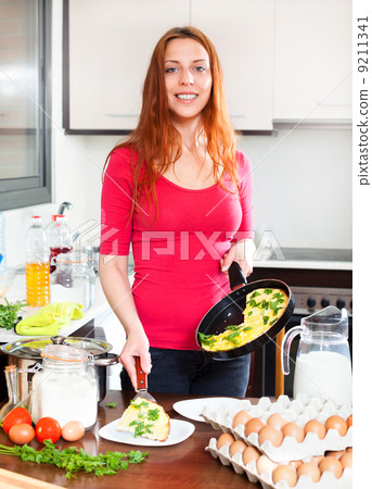 Girl with cooked omelet in home Girl with cooked omelet in home 9211341