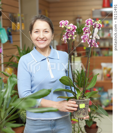 Happy mature woman with Phalaenopsis 9211491