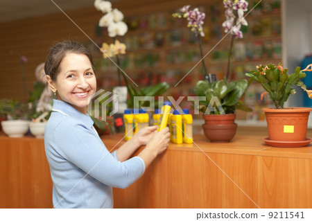 woman chooses liquid fertilizer at store woman chooses liquid fertilizer at store 9211541