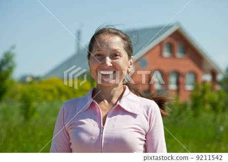 Happy woman against her home Happy woman against her home 9211542