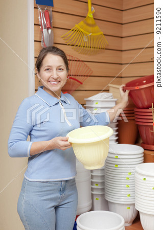 woman chooses plastic flower pot 9211590