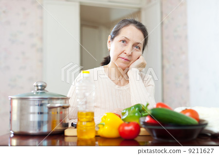 weariness mature woman at kitchen weariness mature woman at kitchen 9211627