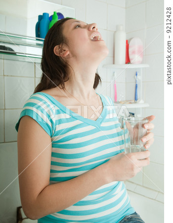 woman with medicine gargling 9212428