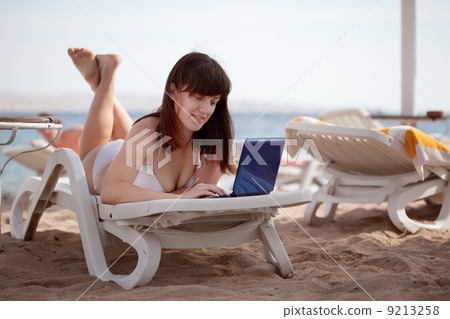 woman using laptop at resort beach woman using laptop at resort beach 9213258
