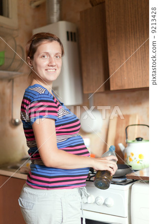 pregnant woman cooks in her kitchen pregnant woman cooks in her kitchen 9213428