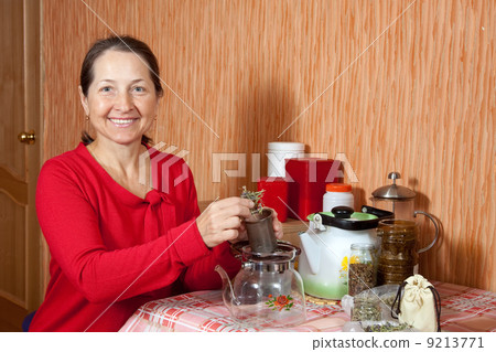 Mature woman brews herbs 9213771