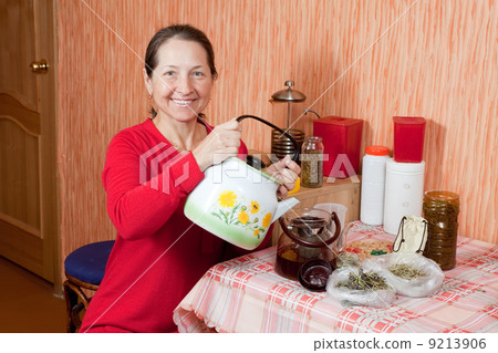 Mature woman brews herbs 9213906