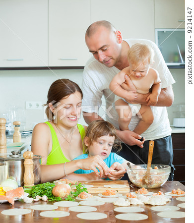 parents with young children dumplings fish cooking in a home kit 9214147
