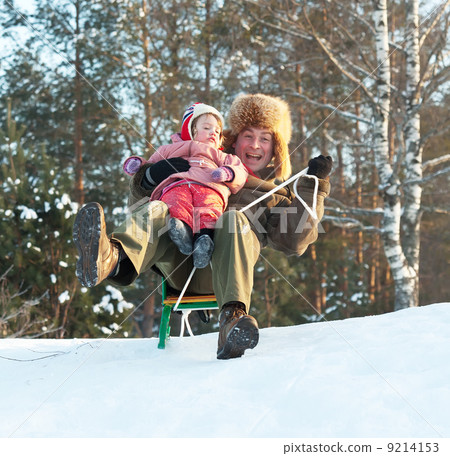 Happy man with child sliding on sleds Happy man with child sliding on sleds 9214153