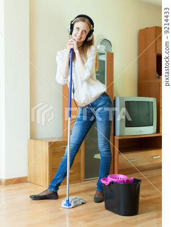 Smiling woman washes the floor with mop Smiling woman washes the floor with mop 9214433