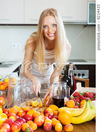 cheerful housewife making cocktail with fruits cheerful housewife making cocktail with fruits 9214435