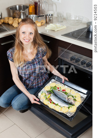 girl cooking raw fish in oven at kitchen girl cooking raw fish in oven at kitchen 9214503
