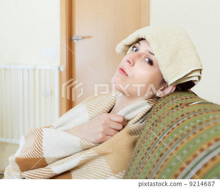 woman having headache holding towel 9214687