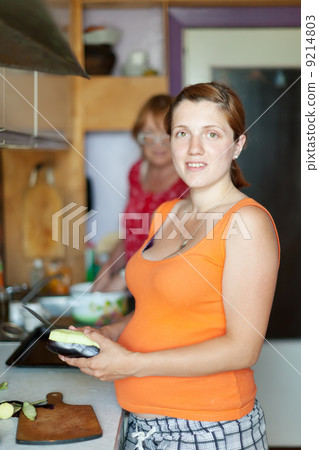 women with vegetables in kitchen 9214803