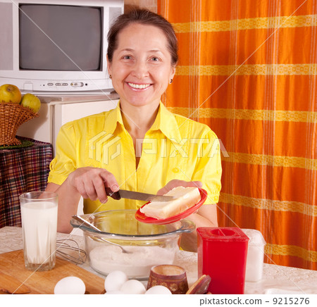 woman adds margarine into dough 9215276