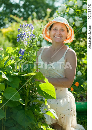Mature woman in Campanula plant 9215298