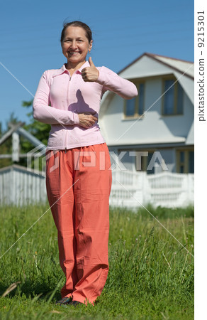 Happy woman in front of new home 9215301