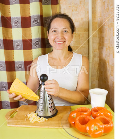 woman grating cheese in her kitchen 9215318