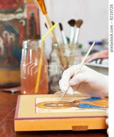 Artist paints of Christian icon at workshop 9219726