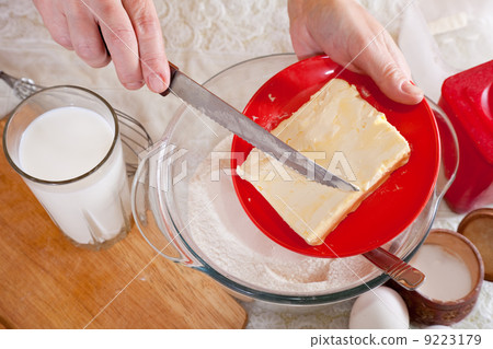 cook hands adds margarine into dough 9223179