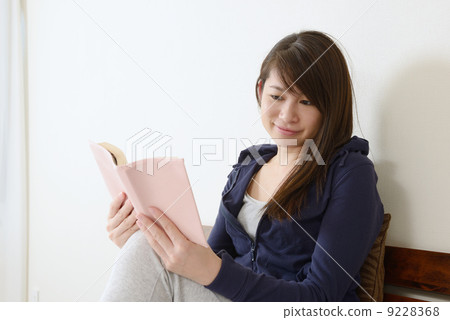 一個年輕的女人在床上聽音樂 一個年輕的女人在床上聽音樂 9228368