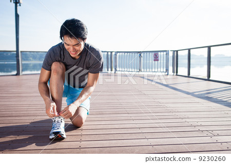 Young Asian Man Tying Running Shoelaces 9230260