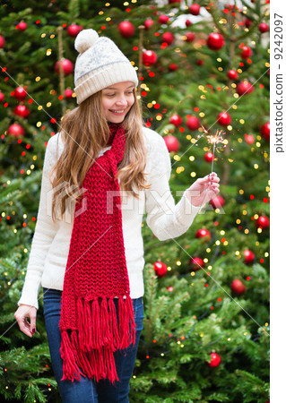 Girl with a sparkler near Christmas tree Girl with a sparkler near Christmas tree 9242097
