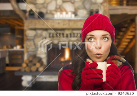 Mixed Race Girl Enjoying Warm Fireplace and Holding Mug 9243620