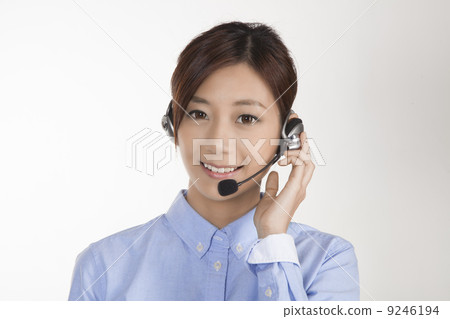 Office woman with headset with mic, holding onto headset Office woman with headset with mic, holding onto headset 9246194