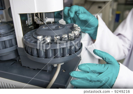 Centrifuge with experiment tubes and hands in gloves 9249216