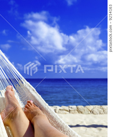 Female leg in hammock on background of ocean and sky Female leg in hammock on background of ocean and sky 9254163
