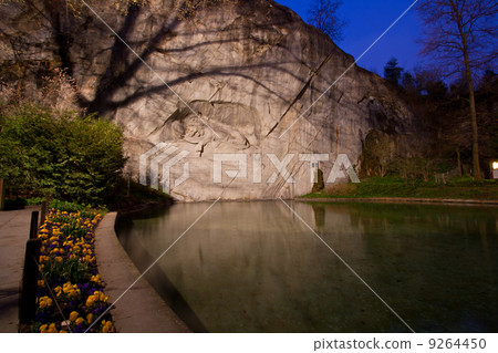 dying lion monument in Lucern Switzerland twilight with flower 9264450