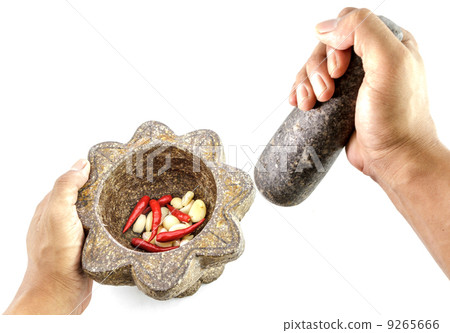 garlic and red chili pepper in stone mortar with hand holding garlic and red chili pepper in stone mortar with hand holding 9265666