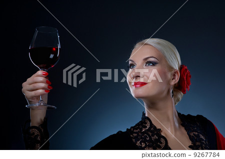 Beautiful flamenco dancer holding a glass of wine Beautiful flamenco dancer holding a glass of wine 9267784