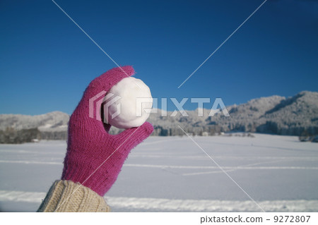 Glove holding snowball winter landscape 9272807