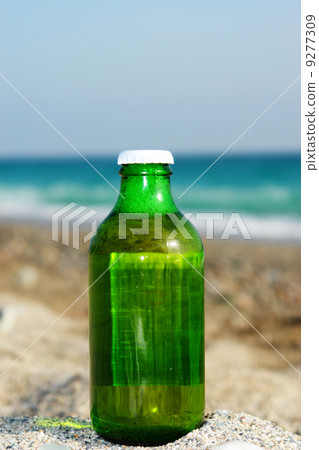 fresh closed beer bottle at beach 9277309
