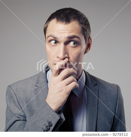Confused Businessman On Gray Background 9278512