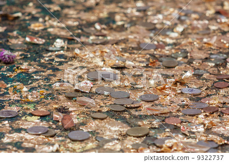 Coinsand golden leaf in the hole  that supposed to be  buddha's 9322737