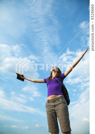 Young woman staying with raised hands 9326660