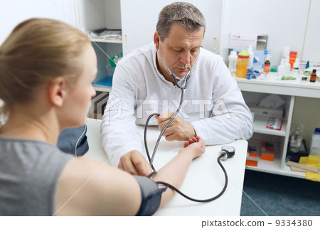 Doctor measures the blood pressure 9334380