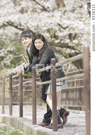 A young businessman under a cherry tree and a school girl 9338315