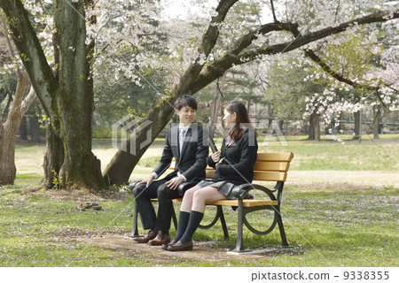 A young businessman under a cherry tree and a school girl 9338355