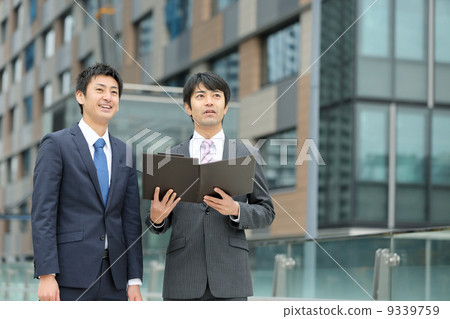 Two businessmen watching documents 9339759