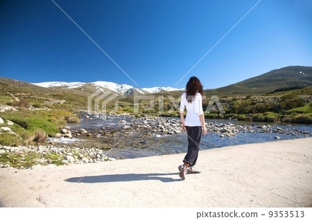 woman hiking next to river 9353513