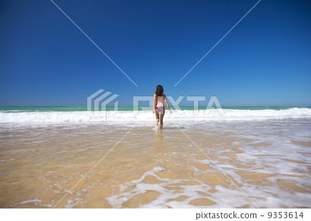 woman running to the ocean at Conil beach 9353614