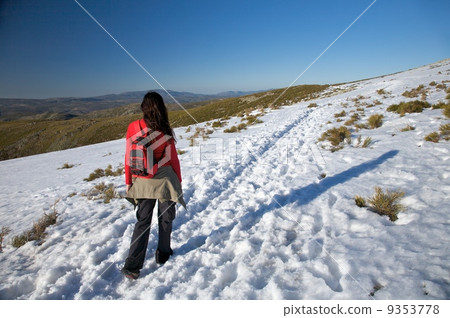 woman with rucksack on snow path 9353778