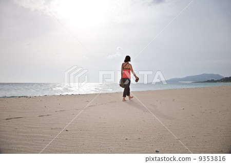 woman taking for a walk at Tarifa beach 9353816